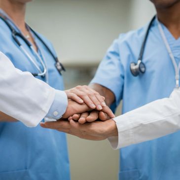 Doctors placing a hand together as a team.